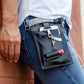A person with a black and gray vegan leather phone pouch with a black and grey vegan leather magnetic wristlet keychain and a black and gray removable three pocket wallet used as a hip bag.